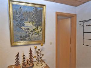 a painting on a wall next to a table with trees at Serene Stay with Garden in Frauenwald +28 photos