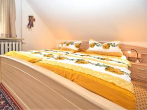 a bed with yellow and white sheets and pillows at Serene Stay with Garden in Frauenwald