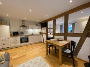 una cucina e una sala da pranzo con tavolo e sedie di Weingut Bindges - Apartment Rosenhof a Traben-Trarbach