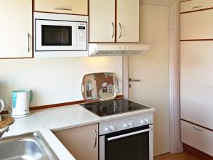 eine Küche mit Herd und Mikrowelle in der Unterkunft 6 person holiday home in Otterndorf in Otterndorf + 5 Fotos
