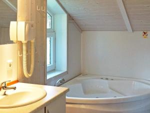 ein weißes Badezimmer mit Badewanne und Waschbecken in der Unterkunft 6 person holiday home in Otterndorf in Otterndorf
