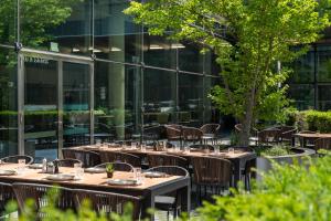 a row of tables and chairs in front of a building at INNSiDE by Meliá München Parkstadt Schwabing in Munich