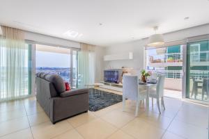 a living room with a couch and a table at 16th Floor with Pool & 180 Sea Views by QuickTrips in Sliema