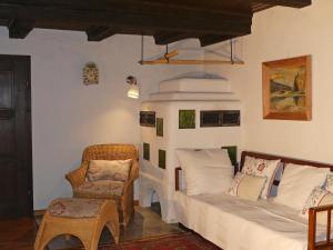 a living room with a bed and a chair at Ferienhaus in Kollnburg mit Garten in Achslach
