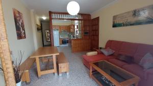 Una sala de estar con un sofá rojo y una mesa. en Casa Naos, en Puerto Naos 8 fotos más