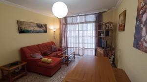 Una sala de estar con un sofá rojo y una mesa. en Casa Naos, en Puerto Naos