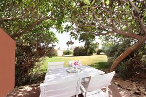 a white table and chairs under a tree at Almog Hotel in Almog +64 photos