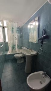 Un baño con dos lavabos, un inodoro y un espejo. en Casa Naos, en Puerto Naos