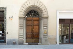 una entrada a un edificio con puerta de madera en Fossi Street Central Apartment, en Florencia