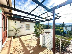 an outdoor patio with a pergola on a house at Harbor View Cottage in Hout Bay