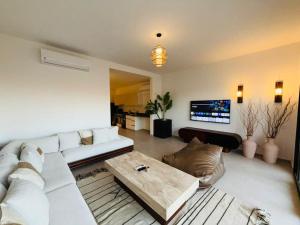 ein Wohnzimmer mit einem weißen Sofa und einem Couchtisch in der Unterkunft 1 Bedroom El Gouna Kamaran in El Gouna + 7 Fotos