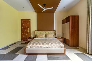 a bedroom with a bed and a ceiling fan at Punya Farms - Luxury 5BR near Isha Yoga in Alāndurai +38 photos