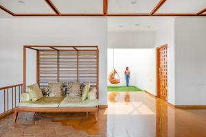 a living room with a couch and a person in the distance at Punya Farms - Luxury 5BR near Isha Yoga in Alāndurai