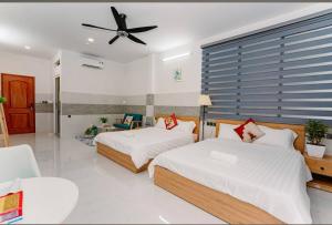 a bedroom with two beds and a ceiling fan at Bonita Boutique Hotel Q5 in Ho Chi Minh City