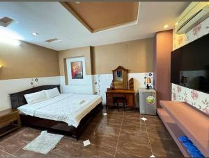 a bedroom with a bed and a desk and a television at Bonita Boutique Hotel Q5 in Ho Chi Minh City