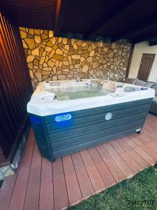 a hot tub sitting next to a stone wall at TatryTop Dom Tatra Home Residence Jacuzzi in Biały Dunajec