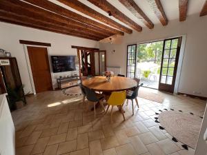 Saint-Hilaire-de-CourtにあるLe Poirier au Roi, Villa avec Piscine, Jacuzzi, Parc, Etang et calmeの木製のテーブルと椅子のあるダイニングルーム