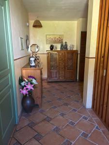 a hallway with a tiled floor with a vase of flowers at Chez Mamie in Cazes-Mondenard +2 photos