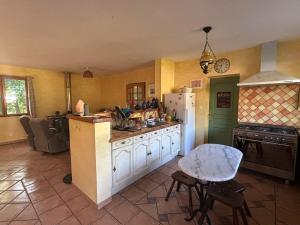 a kitchen with white cabinets and a white refrigerator at Chez Mamie in Cazes-Mondenard