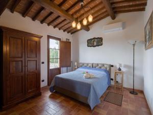 a bedroom with a bed with a blue bedspread at Charming Retreat in Armaiolo in Rapolano Terme
