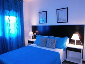 a blue bedroom with a large bed with blue pillows at Hostal Don Pepe in Figueres