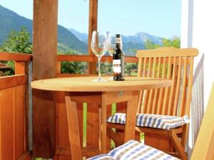 a table with a bottle of wine and a glass at Ferienwohnung in Halblech in Halblech