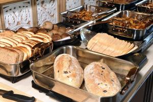 a bunch of different types of bread and pastries on a counter at Almog Hotel in Almog