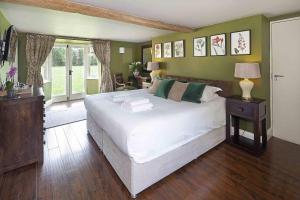 a bedroom with a large white bed with green walls at Hill Farm in Oxford