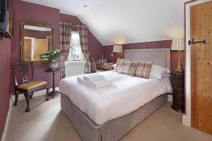 a bedroom with a large bed and a mirror at Hill Farm in Oxford
