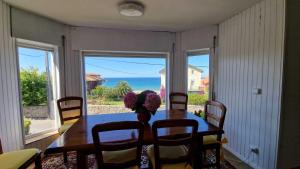 a dining room table with a vase of flowers on it at Chalet con jardín y vistas al mar in Suances