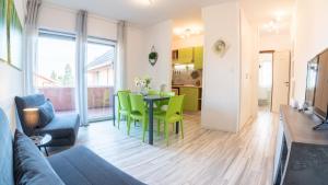 a living room with a table and green chairs at BookingPeschiera bei Gardaland in Peschiera del Garda