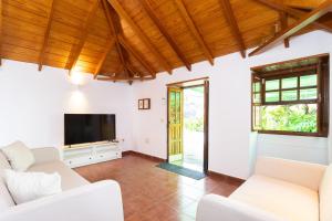 a living room with white furniture and a flat screen tv at OkStay - Casa Canaria en El Sauzal in Tacoronte