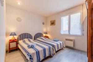 a bedroom with two beds and a window at Chez Paddy - Familial - Paisible in Challans