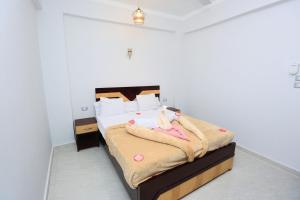 a bedroom with a bed with a stuffed animal on it at nile shores hotel in Al Aqālitah