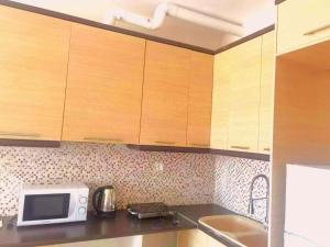 a kitchen with wooden cabinets and a microwave at Thalassa View c2 in Khalkoútsion