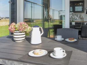Harboørにある4 person holiday home in Harboøre-By Traumの2つのカップとドーナツの皿が置かれたテーブル