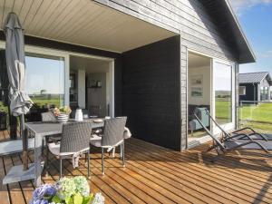 Harboørにある4 person holiday home in Harboøre-By Traumのデッキにテーブルと椅子が置かれたパティオ