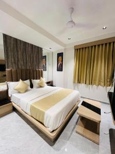 a bedroom with a large bed and a television at Hotel Prominent in Ahmedabad