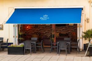 a blue awning on a restaurant with tables and chairs at Royal Hotel in Scarborough