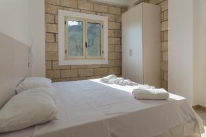 een slaapkamer met een groot wit bed met een raam bij La casetta b&b in Ceraso +14 foto's