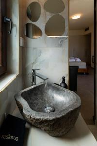 a stone sink with a faucet in a bathroom at FOS signature living in Kókkinos Pírgos
