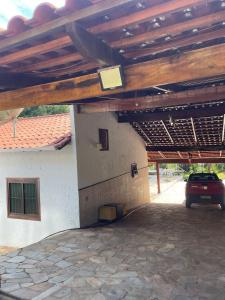 a building with a car parked under a wooden roof at Rancho Monte Verde in Elói Mendes +5 photos