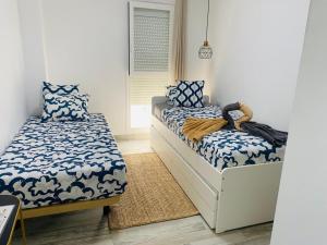 Un dormitorio con dos camas y una ventana. en TULUM MEDANO BEACH, en El Médano