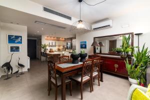 a dining room with a table and chairs and a kitchen at FOS signature living in Kókkinos Pírgos