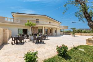un patio con mesas y sillas frente a una casa en Agriturismo Cutura, en Parabita