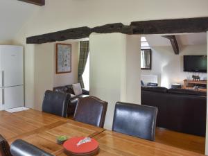 een woonkamer met een tafel, stoelen en een bank bij Combe Cottage-Uk42228 in Low Borrowbridge