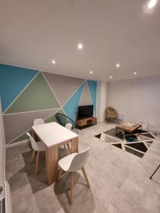 una habitación con una mesa y sillas y un sofá en VALSCOSY parking - Activités illégales interdite, en Valenciennes