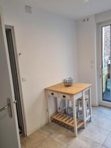 una pequeña mesa de madera en una habitación con ventana en VALSCOSY parking - Activités illégales interdite, en Valenciennes