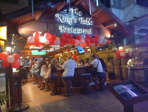 a group of people standing at a bar in a pub at Inn House- SHA Extra Plus in Pattaya Central +95 photos