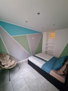 Un dormitorio con una cama y una silla dentro. en VALSCOSY parking - Activités illégales interdite, en Valenciennes
